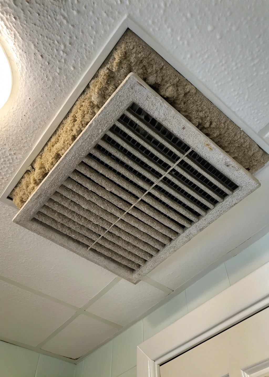 Dusty bathroom exhaust fan before professional cleaning