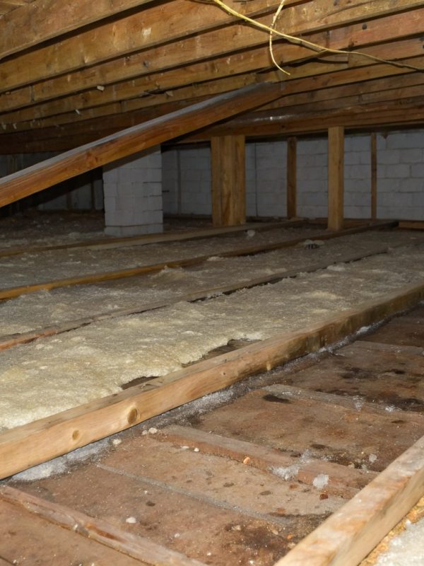 Moisture-damaged insulation batts in a residential subfloor space prior to replacement